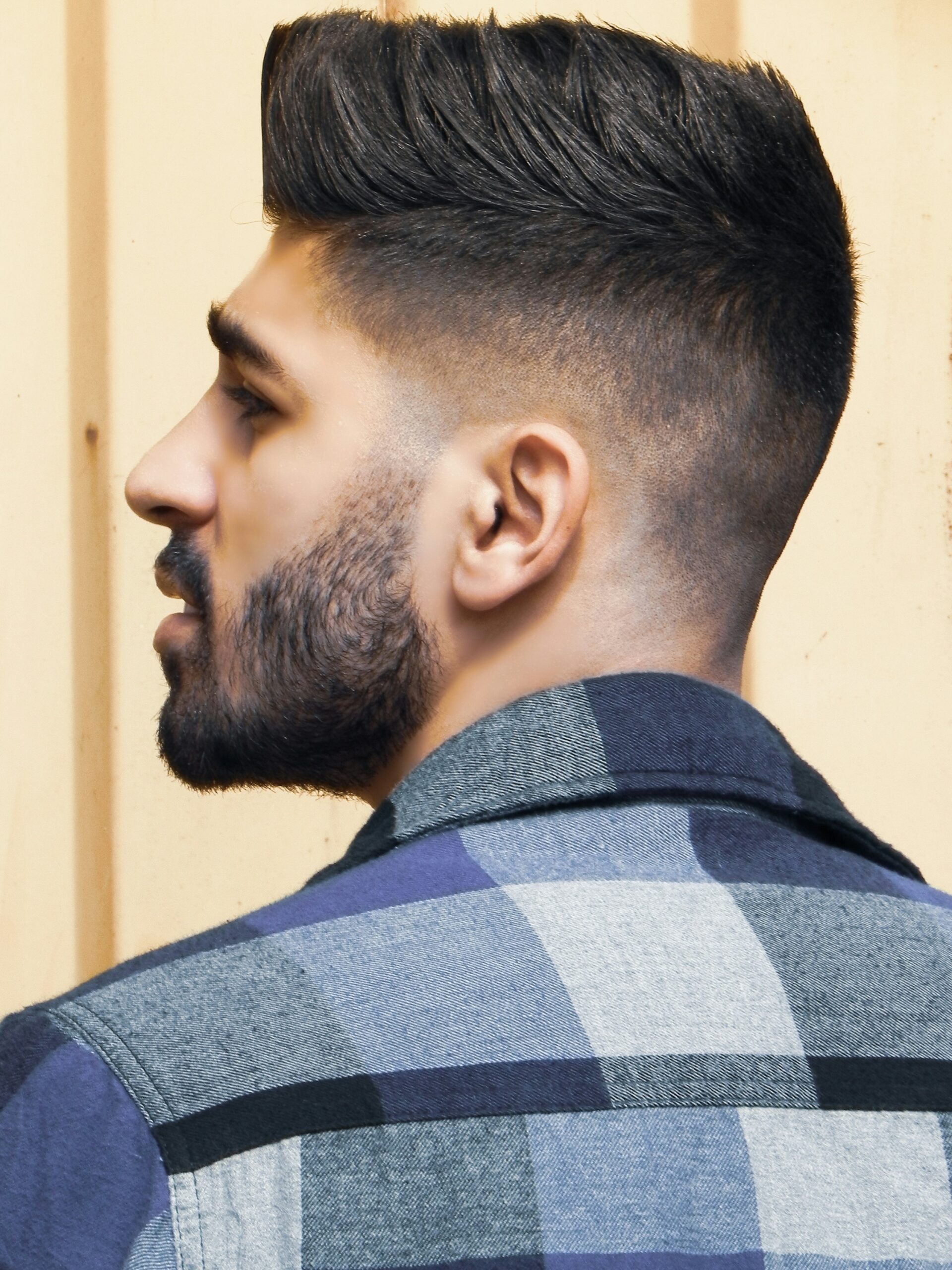 Seitenporträt eines Mannes mit Faux-Hawk-Frisur und einem High Taper Fade