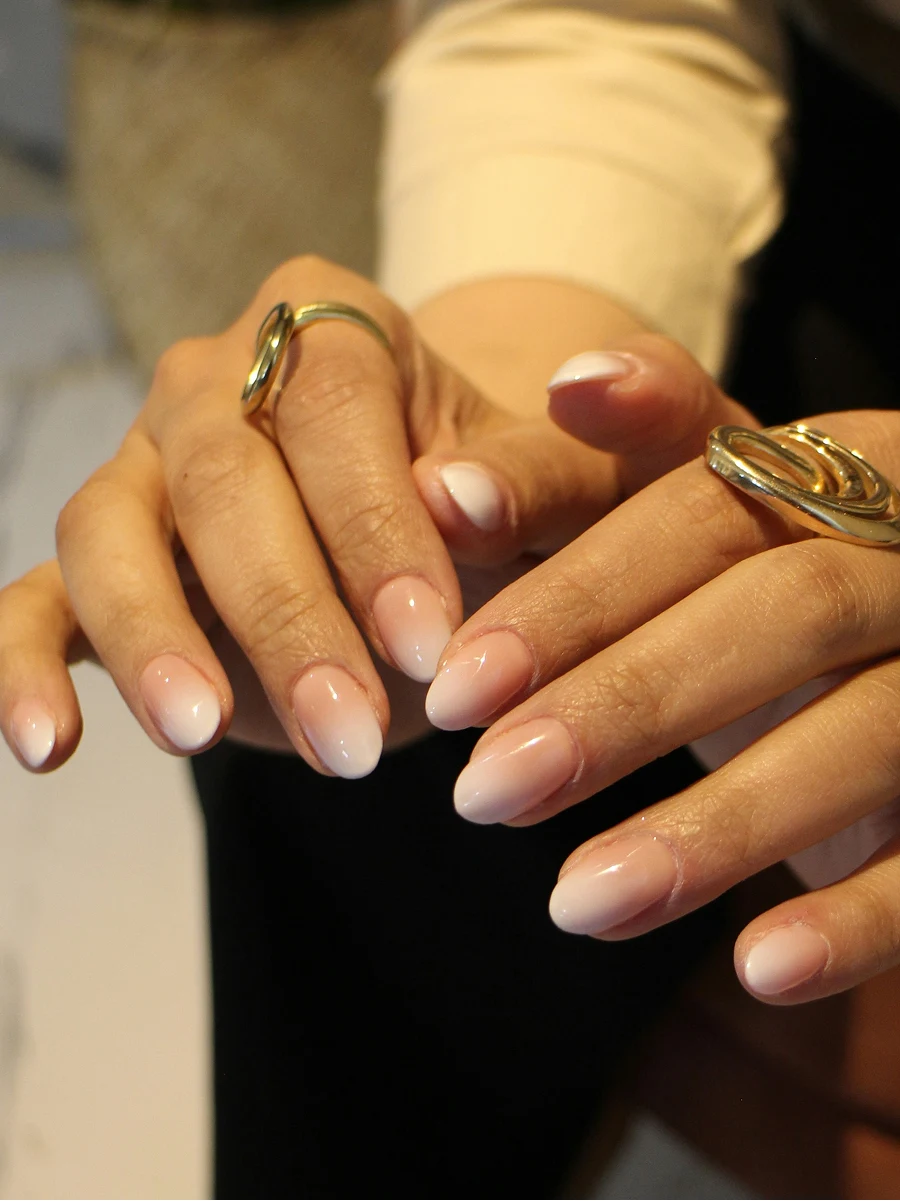 Nahaufnahme einer Ombré-Shellac-Maniküre in klassischen Nude-Tönen direkt nach der Behandlung im Salon