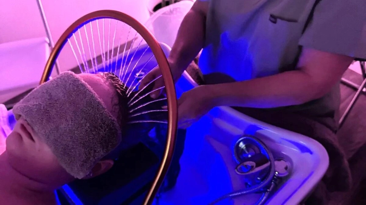 Aufsicht auf eine Fachkraft, die einer Kundin während eines Japanese Head Spa die Haare wäscht