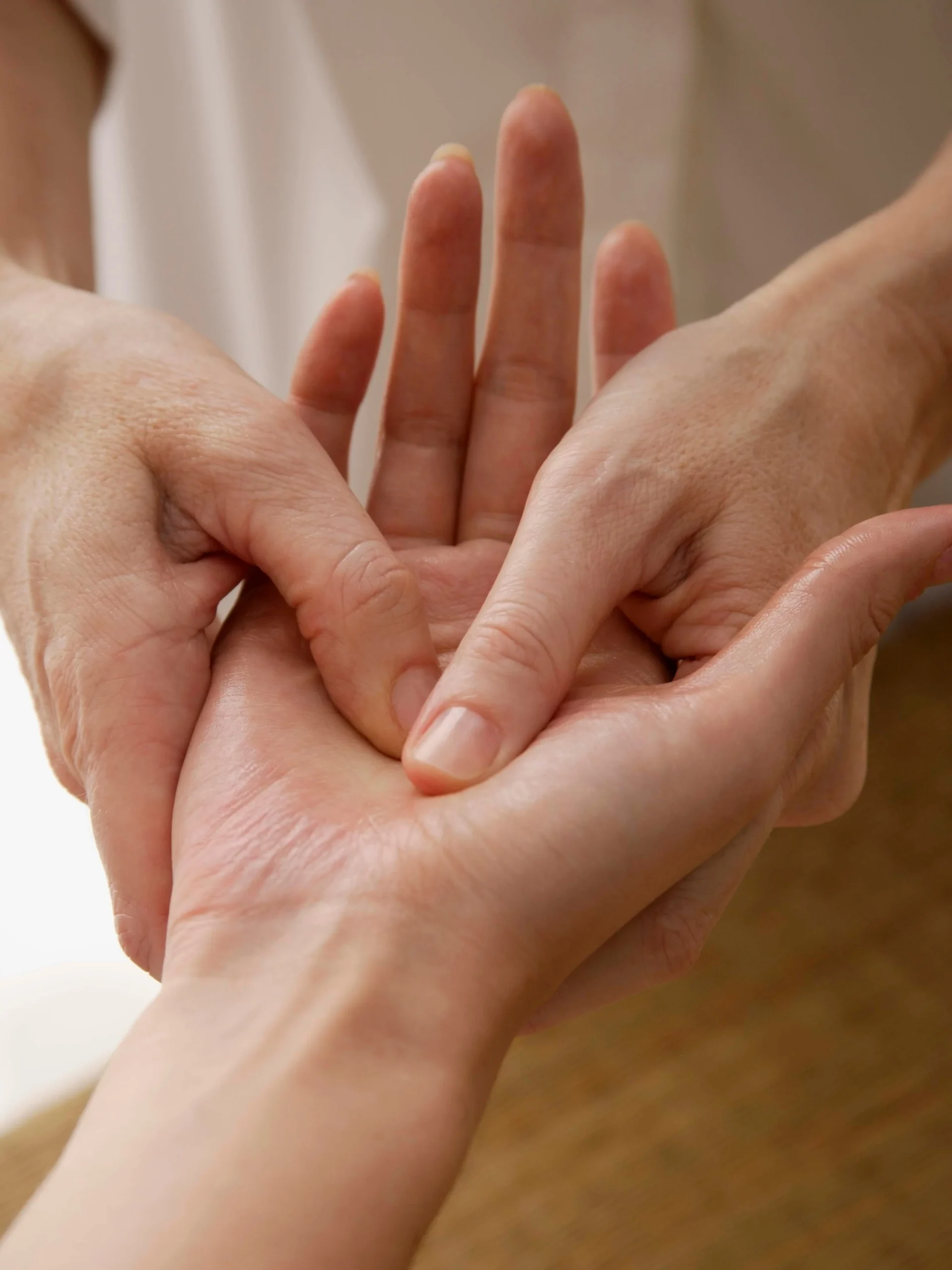 Nahaufnahme, wie eine Fachkraft die Hand einer Kundin behandelt