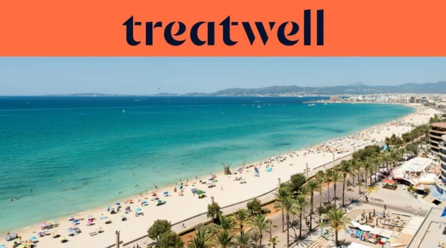 Luftaufnahme der Playa de Palma auf Mallorca, mit einem langen, geschwungenen Streifen goldenen Sandes, Reihen von Sonnenschirmen, ruhigem türkisfarbenem Wasser und einer palmengesäumten Promenade entlang der Stadt, mit Hügeln in der Ferne unter klarem blauem Himmel.