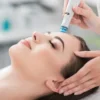 Nahaufnahme einer entspannten Frau mit geschlossenen Augen während einer HydraFacial-Behandlung in einem ruhigen Salon