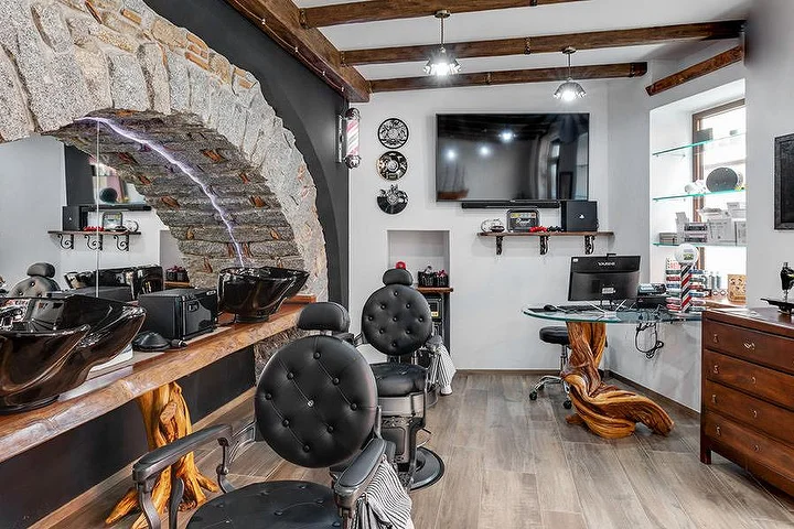 Rustikaler Barbier-Stuhl vor einer steinernen Bogenwand bei La Bottega di Pablo im Bergort Lanusei.